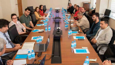 Çalıştaya katılan akademisyen ve araştırmacılar uzun bir masa etrafında karşılıklı oturuyor.