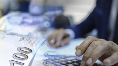 100 liralık kağıt bankonot ve bilgisayar klavyesi üzerinde bir el var.