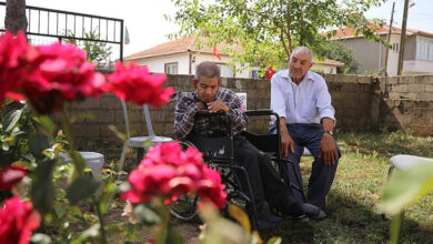 Baba Mahsut Zambak, tekerlekli sandalye kullanıcısı Gökhan Zambak evlerinin bahçesinde oturup vakit geçiriyorlar.