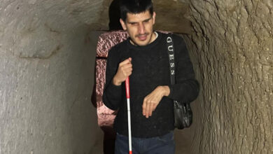 Görme engelli Yusuf Ak, beyaz bastonuyla bir mağara içinde turist olarak geziyor.