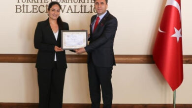 Bilecik Valisi Şefik Aygöl, makam odasında Hale Uçuş'a plaket veriyor.