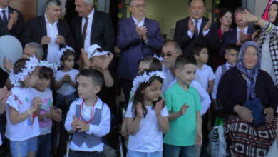 Tekerlekli sandalye kullanan engelli birey, anasınıfı öğrencileri ve öğretmenler ile katılımcılar tempolu bir şekilde alkış yapıyor.