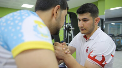 Engelli birey Abdulsamet Ocakoğlu, antrenörü ile bilek güreşi yapıyor.