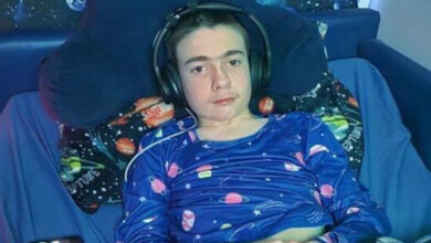 Epilepsi cihazı takılan Oran Knowlson, kulak üstü kulaklık takarak bir yatakta uzanıyor.