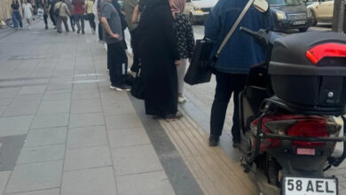 Görme engelli bireylerin gidecekleri yolu bulmaları için özel olarak tasarlanmış sarı renkli tırtıklı yol üzerinde motosiklet ve insanlar var.