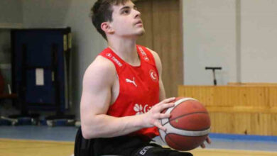 Tekerlekli sandalye basketbol takımında oynayan sporcu Bilal Mert Taşoğlu, basketbol sahasında tekerlekli sandalye üzerinde ve elindeki basketbol topu ile atış yapmaya hazırlanıyor.