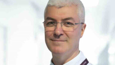 Nöroloji Uzmanı Doç. Dr. Yakup Türkel, görsele göre hafif sağa dönük ve beyaz üniforması ile fotoğraf için poz veriyor.