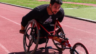 Bedensel engelli sporcu, özel tasarlanmış üç tekeri olan sandalyesini sürüyor.