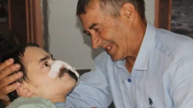 Serebral palsi'li Ertan Eyilik'e, babası Zeki Eyilik gülümseyerek bakıyor.