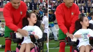 Tekerlekli sandalye kullanan engelli çocuğun elinden tutup destek olan Cristiano Ronaldo görselde var.