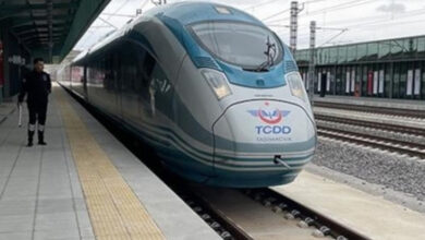 TCDD'ye bağlı bir adet hızlı tren ve trenin yanında bir görevli var.