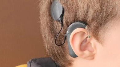 İşitme engelli bir çocuğun kulağının üstüne takılmış işitme cihazı ve cihaza kabloyla bağlı bir parça çocuğun kafasına yapıştırılmış.