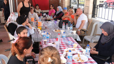 Türkiye Sakatlar Derneği Kemer Temsilcisi, engelli bireyler ve aileleri masa etrafında oturuyor.