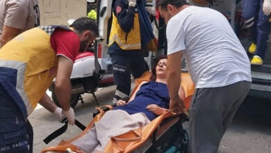 Yürüme yeti kaybı olan engelli kadın, sedye üzerinde yatırılarak 112 ambulans personeli tarafından ambulansa bindiriliyor.