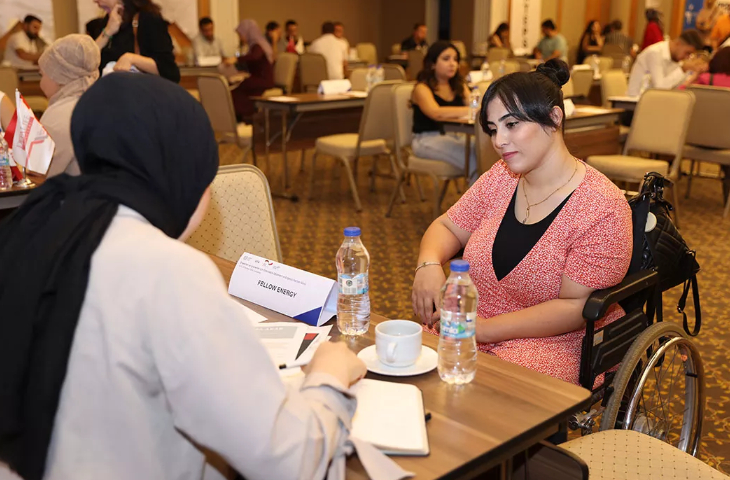 Tekerlekli sandalye kullanıcısı engelli kadın, işverenler ile mülakat yapıyor.