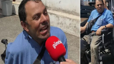 Tekerlekli sandalye kullanıcısı engelli birey Okan Turan, kırmızı renkli bir mikrofona konuşuyor.