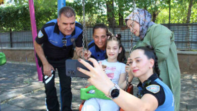 Şilan Koca ve Bingöl Emniyetinde görevli polis memurları, parktaki salıncakta oturan Şilan’ın çevresinde durarak birlikte fotoğraf çekiliyorlar.