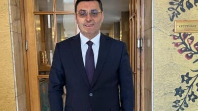 Milletvekili Serkan Bayram, takım elbise giymiş ve gözlük takmaktadır.