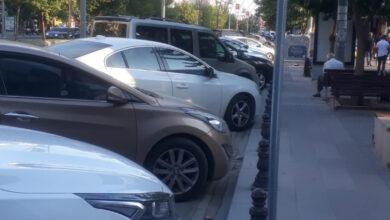 Cadde üzerinde yer alan park alanına birçok otomobil hafif çapraz şekilde park edilmişler.