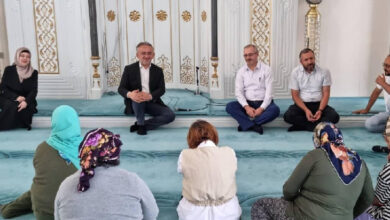 Bayburt Merkez Hacı Kıyasi Şentürk Camisinde düzenlenen programda İl Müftüsü Bayram Danacı ve engelli bireyler halı üzerinde oturup konuşuyorlar.