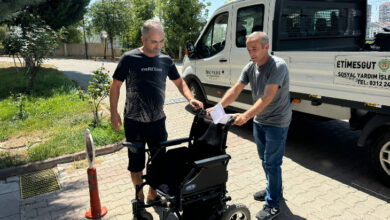Etimesgut Belediyesi çalışanları, akülü tekerlekli sandalyeyi engelli bireyin ailesine teslim ediyorlar.
