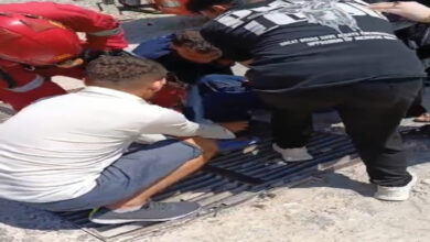 Fotoğrafta, zihinsel engelli bireyin sıkışan ayağını itfaiye ekipleri ve engelli bireyin yakınları tarafından mazgalın içerisinden çıkartılmaya çalışılıyor.