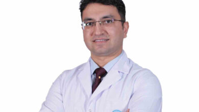 İç Hastalıkları Uzmanı Dr. Muhammet Bilici, beyaz renkli doktor üniforması giymiş bir şekilde ayakta fotoğraf çekimi için poz veriyor.