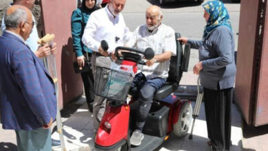 Kocasinan Belediye Başkanı Ahmet Çolakbayrakdar ve yaşlı engelli çifte akülü üç tekerli olan bir sandalye hediye ediyor.