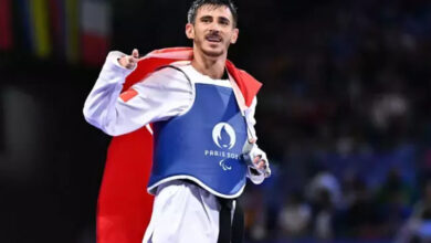 Milli para tekvandocu Mahmut Bozteke, altın madalya kazandıktan sonra Türkiye bayrağını omuzuna bağlayarak ve koşar adımlarla galibiyet sevincini gösteriyor.