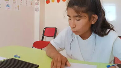 Görme engelli birey Sibel Nakçi, braille alfabesi ile birlikte yazılı bir metni okuyor.