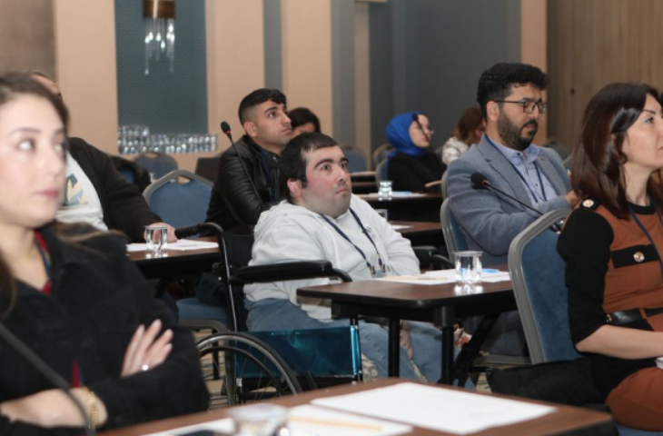 Tekerlekli sandalye üzerinde oturan bedensel engelli birey Yaşadıkça.com'un haber editörü Alper Okçuoğlu’nun etkinlikten bir fotoğrafı.
