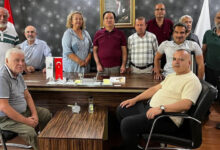 Türkiye Sakatlar Konfederasyonu Başkanı Yusuf Çelebi ve Yönetim Kurulu üyeleri toplantı sonrası fotoğraf çekimi için birlikte duruyorlar.