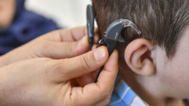 Fotoğrafta, işitme engelli bireyin kulağına işitme cihazı takılıyor.