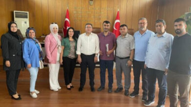 Aksaray İl Genel Meclisi Başkanı Latif Ağır ve engelli dernek başkanları makam odasında yan yana durarak fotoğraf çekimine katılıyorlar.