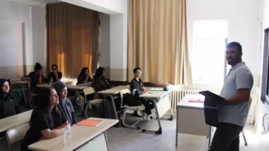 Görme engelli birey Ramazan Dağ, sınıfta öğrencilerine ders anlatırken çekilmiş bir fotoğraf. Dağ, elinde tuttuğu tablet aracılığı ile notlarını öğrencilerine aktarıyor.