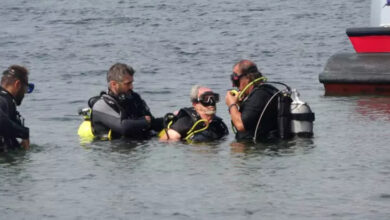 Fotoğrafta, engelli birey dalış eğitmenleri tarafından gerekli teçhizatları takılarak denize dalmak için su yüzeyinde hazırlanıyor.