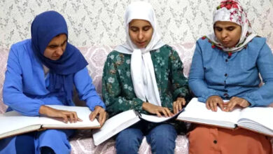 Türkan, Sibel ve Hamide Akçin kardeşler, braile alfabesi ile yazılmış Kuran-ı Kerim'i okuyorlar.