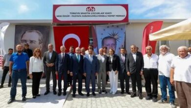 Bir binanın üzerinde “Türkiye Spastik Çocuklar Vakfı Neşe Özgür-Mustafa Sabuncuoğlu Engelli Hizmet Merkezi” yazan bir tabela var. Binanın önünde ise protokol üyeleri ve vakıf üyeleri toplu fotoğraf çekimi yapıyor.