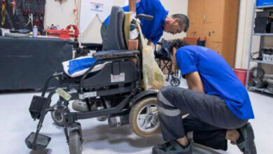 İzmir Büyükşehir Belediyesi'ne bağlı Tekerlekli Sandalye Bakım Onarım İstasyonu'nda çalışan iki personel akülü tekerlekli sandalye tamiratı yapıyor.