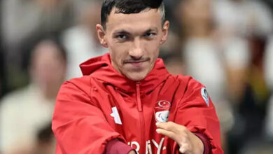 Paralimpik sporcu Umut Ünlü, üzerinde Milli Takım forması ve yüzmeye hazırlanıyor.