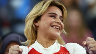 Milli para halterci Nazmiye Muratlı, her iki elini yumruk şeklini yaparak ve kafası fotoğrafa göre hafif sağa doğru dönük şekilde gülümseyerek başarısına seviniyor.