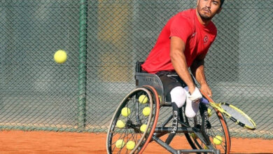 Tekerlekli sandalye tenis quad kategorisinde milli sporcu Ahmet Kaplan, elindeki tenis raketi ile topa vuruş yaptıktan sonra çekilmiş bir fotoğraf.