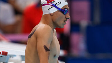 Paralimpik yüzücü Umut Ünlü, havuzun kenarında mavi renkli gözlüğü, başında adının yazılı olduğu beyaz bir bone takılı bir şekilde müsabaka için hazırlanırken çekilmiş bir fotoğraf. Sporcunun üstünde kıyafet yok.