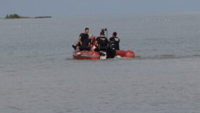 Denizin içerisinde hareket eden bir bot ve botun üzerinde arama kurtarma ekipleri var.