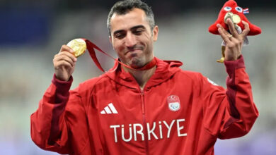 Milli para atlet Serkan Yıldırım, kazanmış olduğu altın madalya sonrası, kürsüde altın madalyasını elinde tutup yukarı doğru kaldırıyor.