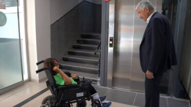 Engelli çocuk Esila Nur Karakaya, Kahta Belediye Başkanı Mehmet Can Hallaç ile birlikte asansör önünde karşılıklı olarak konuşuyorlar.