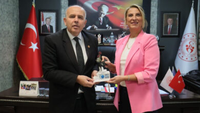 Denizli Gençlik ve Spor İl Müdürü Ömer İlman, Beyazay Derneği Denizli Şube Başkanı Dilek Yüksel Kahveci’den hediye edilen figürü alıyor.