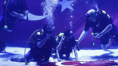 Sualtına dalış yapan sporcular ve engelli bireyler Türk bayrağı açarak gösteri yapıyor.