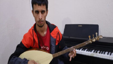Doğuştan görme engelli olan Yakup Albur, elinde tutmuş olduğu bağlama müzik aletini tellerine vurarak çalıyor.