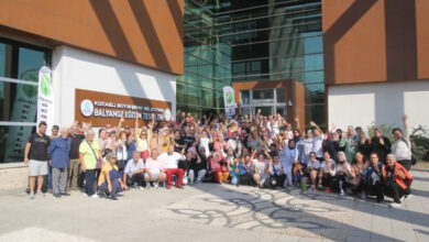 Fotoğrafta, işitme engelli bireyler fotoğraf çekimi için toplu bir şekilde poz veriyor.